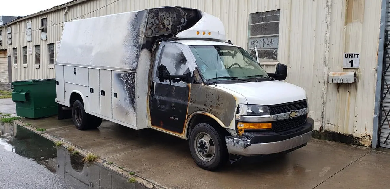Fire-damaged Chevy Express utility truck before repair